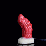 Red dragon anal plug on white textured base, side angle