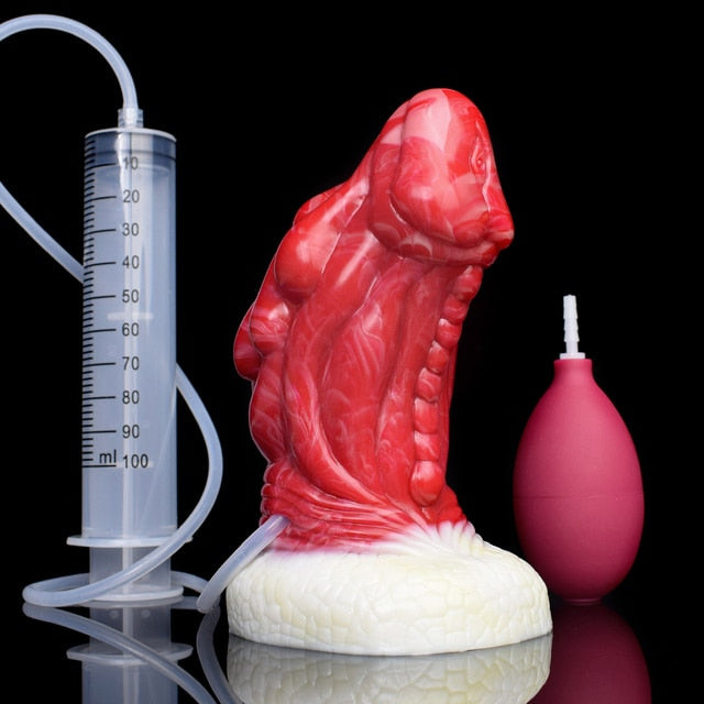 Red dragon anal plug with white base next to syringe and pink bulb