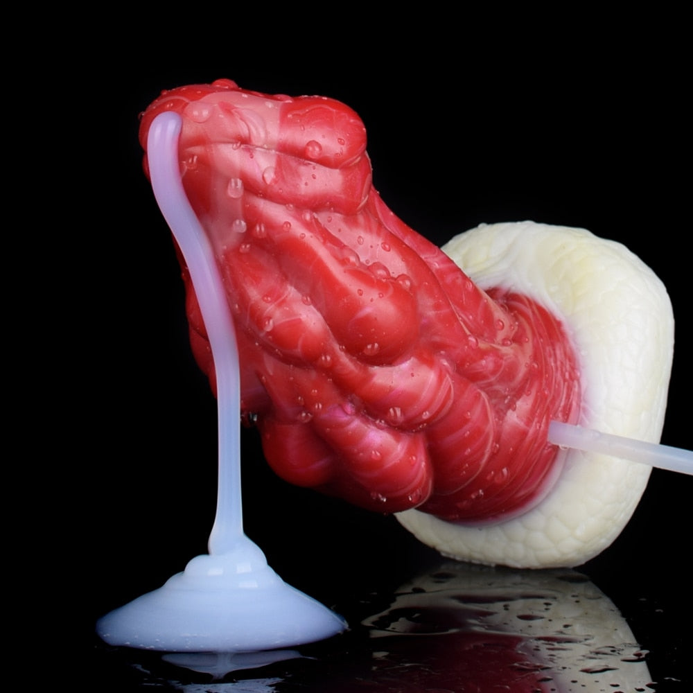 Red dragon anal plug with clear tube and white base, angled close-up