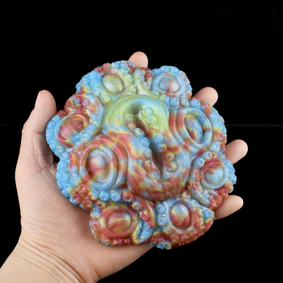 Octopus grinder sex toy, pastel blue and pink swirl texture, held in hand
