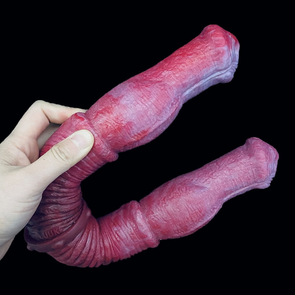 Double-ended horse dildo in pink-red with ribbed grip section and rounded ends, held by hand