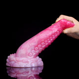 Side view of curved octopus tentacle butt plug, pink translucent with suction texture
