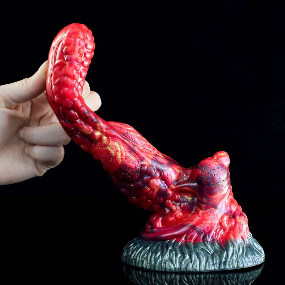 Hand holding curved red monster tongue anal dildo with textured blue-gray base