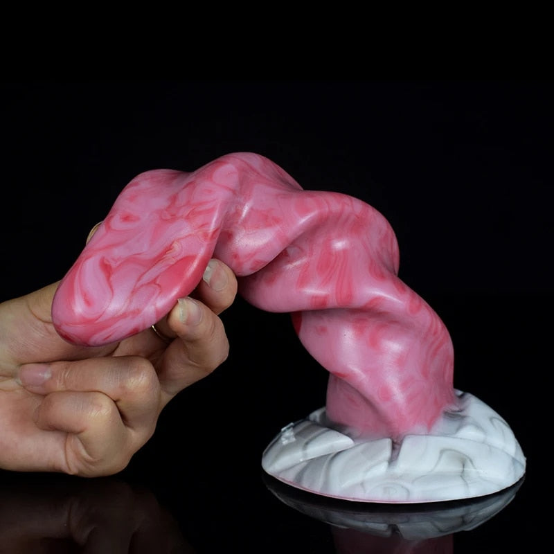 Hand holding pink swirled tentacle dildo; ribbed spiral body with white marble-look base