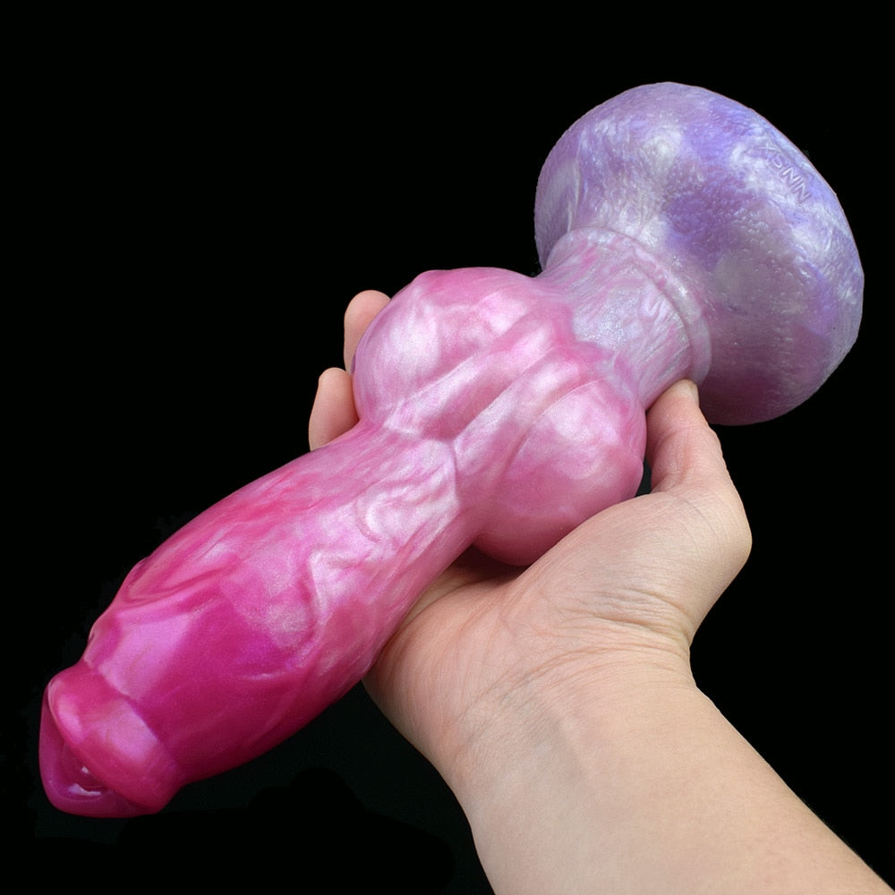 Pink dog-shaped sex toy with large purple knot and rounded head, hand-held